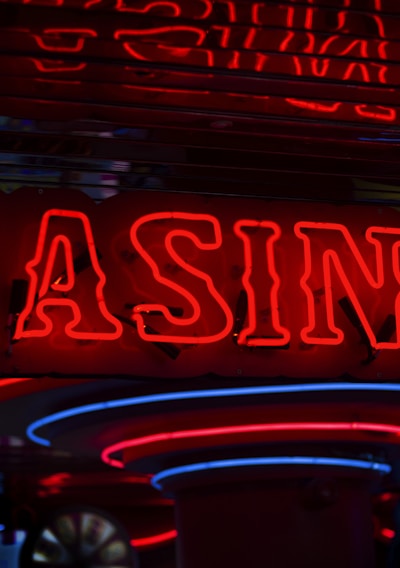 Neon lights display the word 'CASINO' in bright red, standing out against a dark background. The vibrant glow reflects a lively and bustling atmosphere.